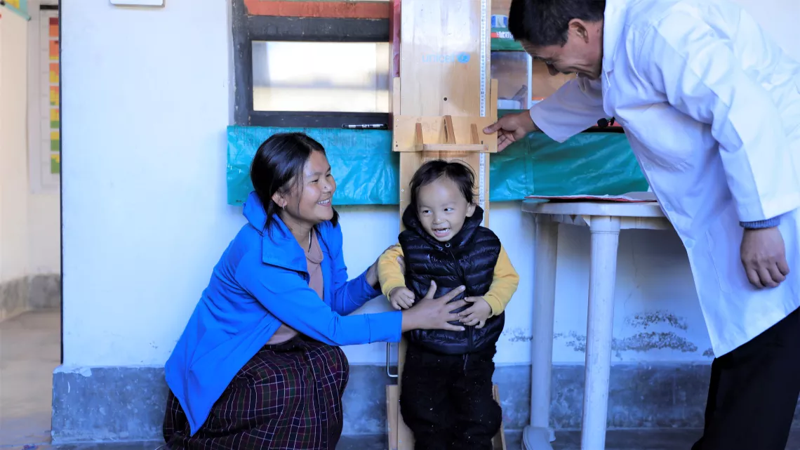 A health worker measures the height of a child 