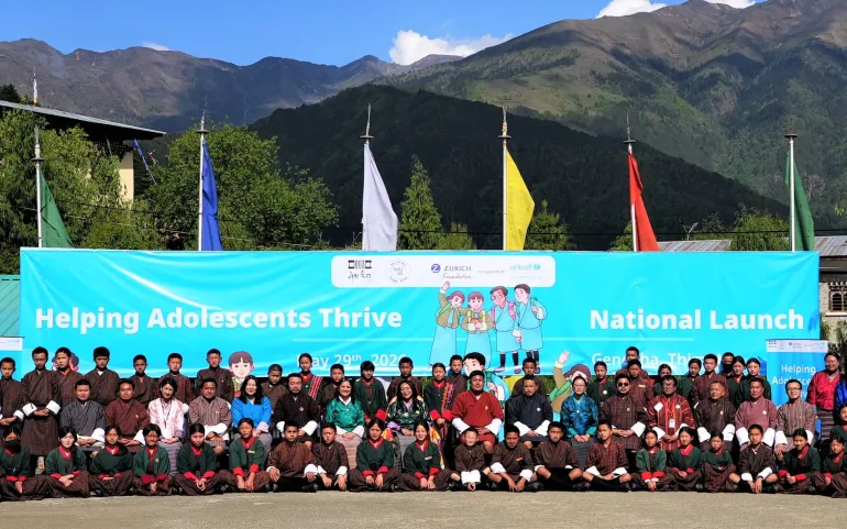 Group photo of students with education minister, teachers and unicef officials infront of a banner 