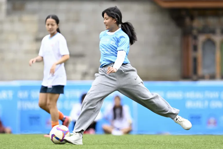 A young girl kicks a ball