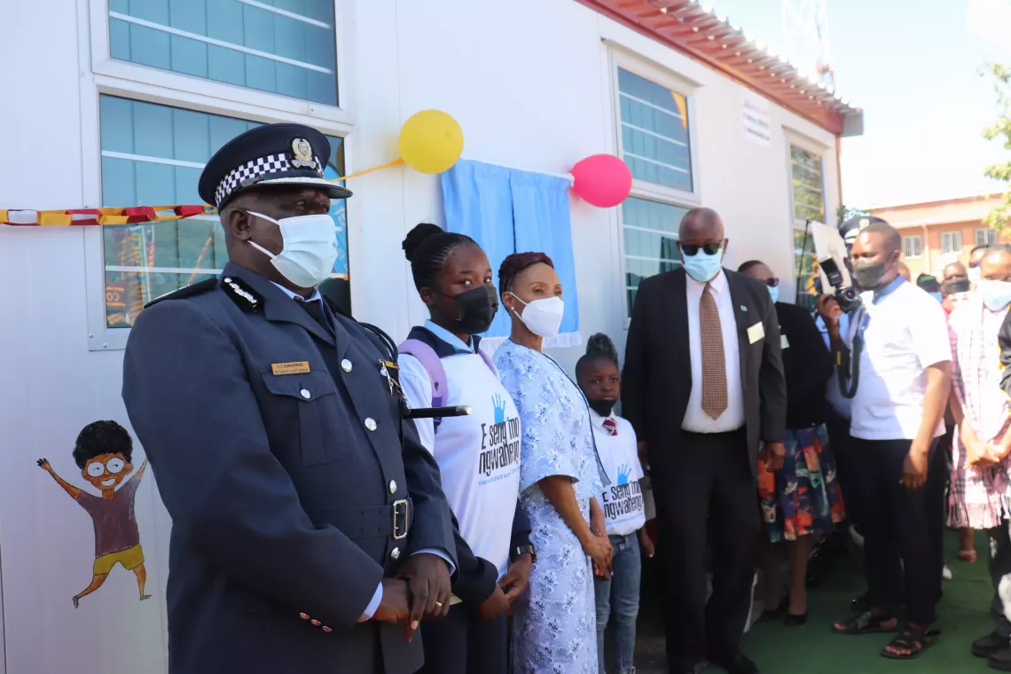 First Lady posing for a photo with children and a police officer at the hand over of a Child Friendly Police center in Shakawe