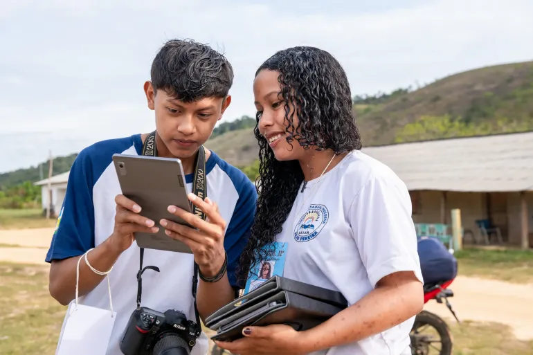 estudantes usam tablet em atividade ao ar livre