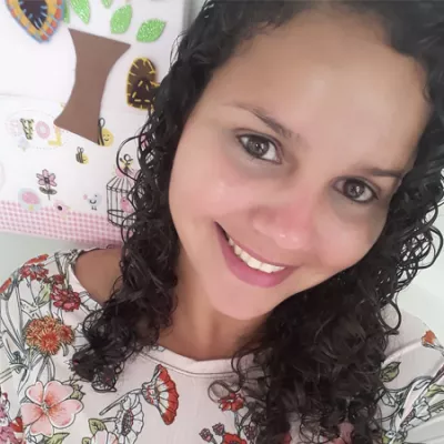 Foto mostra o rosto de uma mulher sorridente