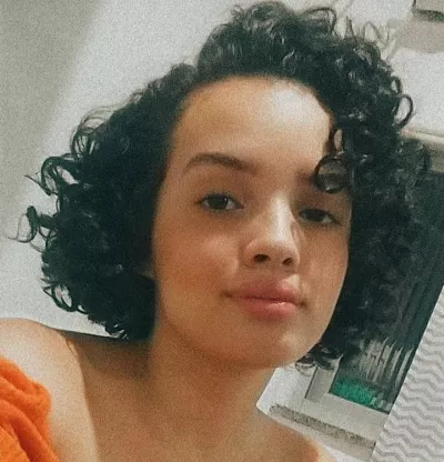 Foto mostra o rosto de uma jovem.