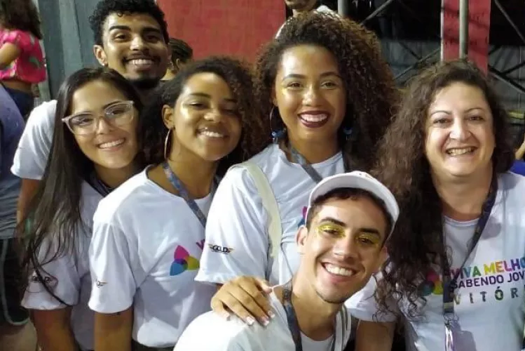 Com mais de 1.000 testes r&aacute;pidos de HIV e s&iacute;filis realizados nas ruas, o projeto adaptou suas atividades durante a pandemia de Covid-19.Na foto, participantes do projeto Viva Melhor Sabendo Jovem em Vit&oacute;ria olham sorridentes para a c&acirc;mera.