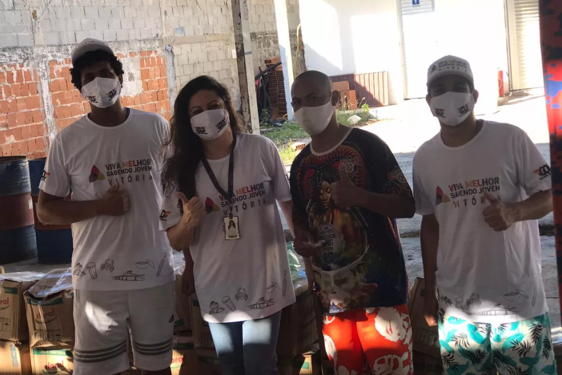 grupo de jovens usando m&aacute;scara est&aacute; atras de uma mesa
