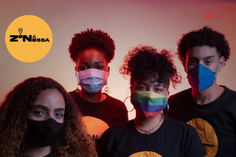 Foto mostra quatro adolescentes usando m&aacute;scara e a camiseta do projeto Zona Nossa. Eles est&atilde;o olhando para a c&acirc;mera.