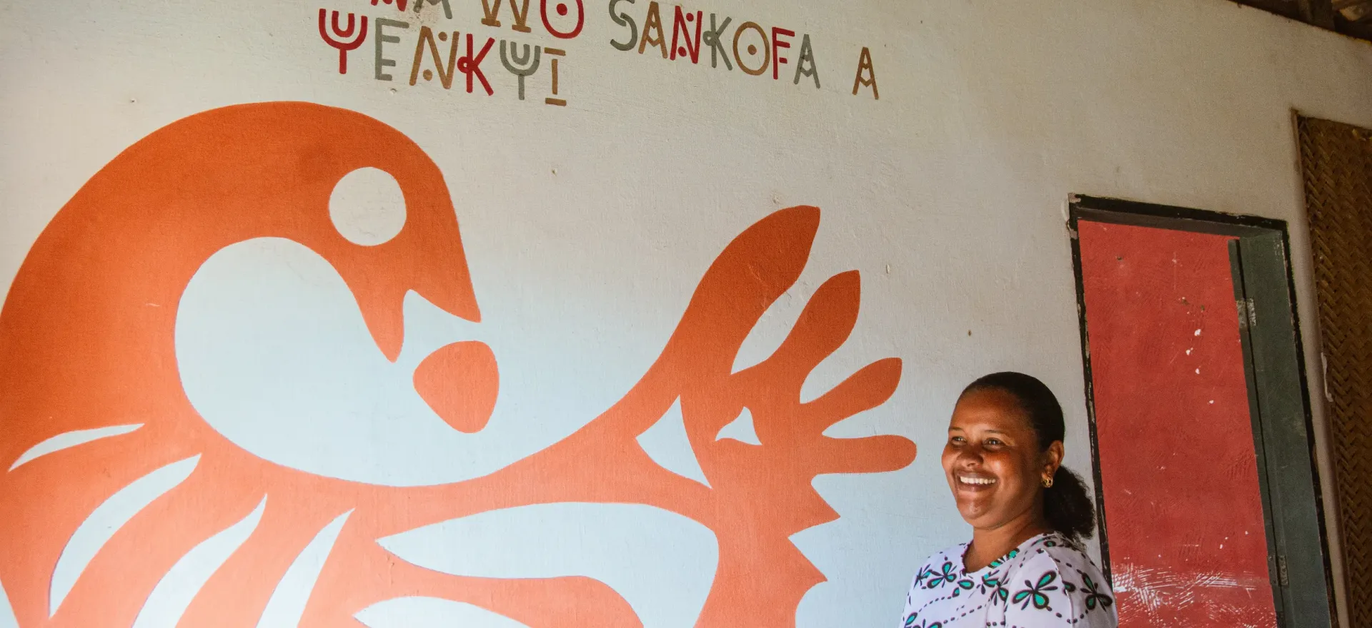 mulher posa em frente a parede pintada 