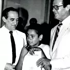 foto em preto e branco mostra dois adultos e uma crian&ccedil;a