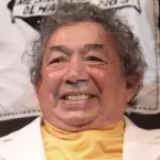 homem vestindo camiseta amarela e terno branco