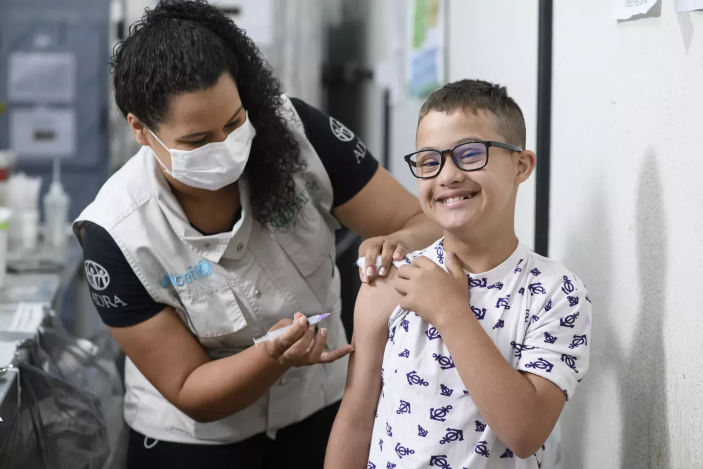 T&eacute;cnica de enfermagem Ang&eacute;lica Morales aplica vacina no bra&ccedil;o de uma crian&ccedil;a com s&iacute;ndrome de down