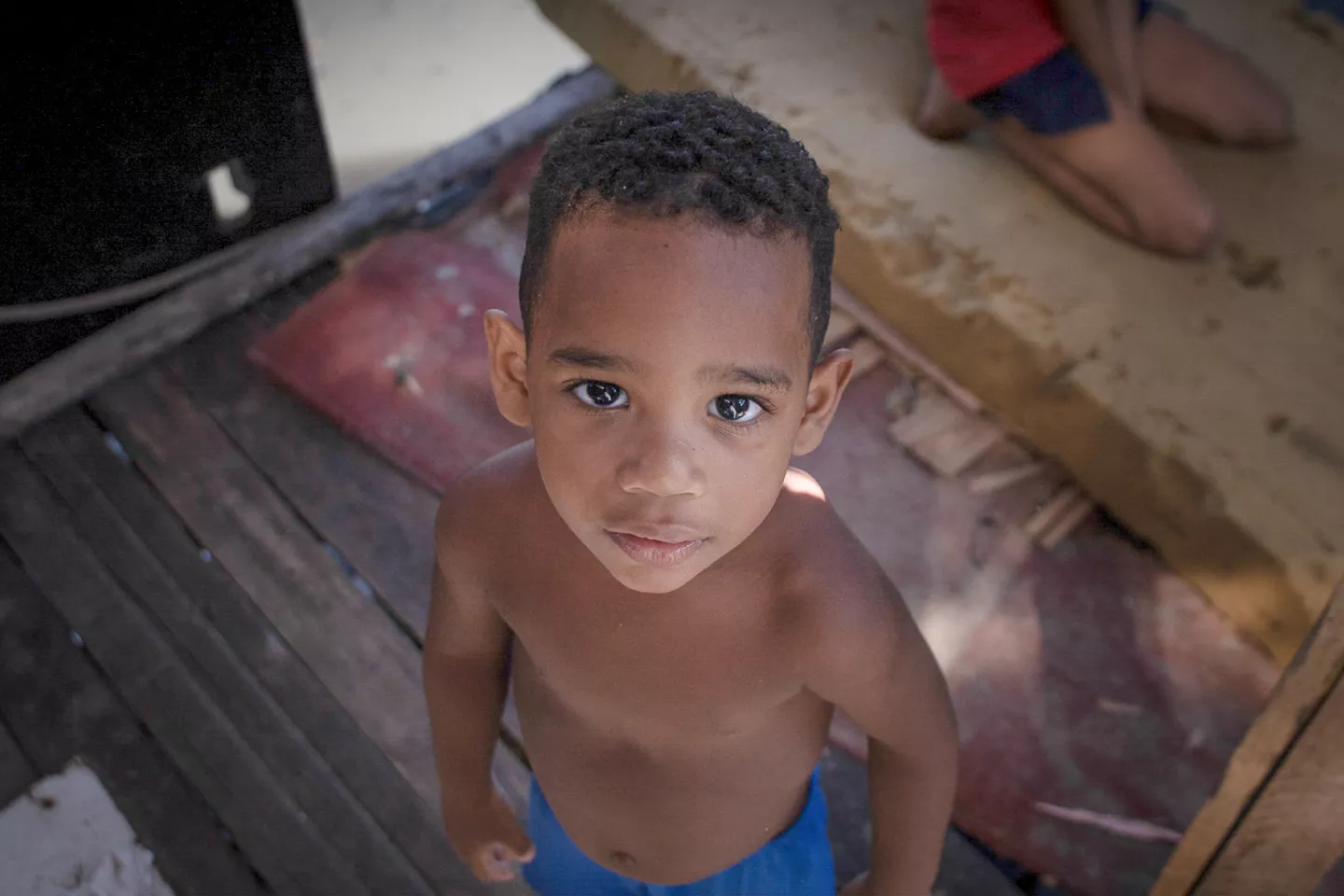 Foto mostra um menino olhando para a c&acirc;mera