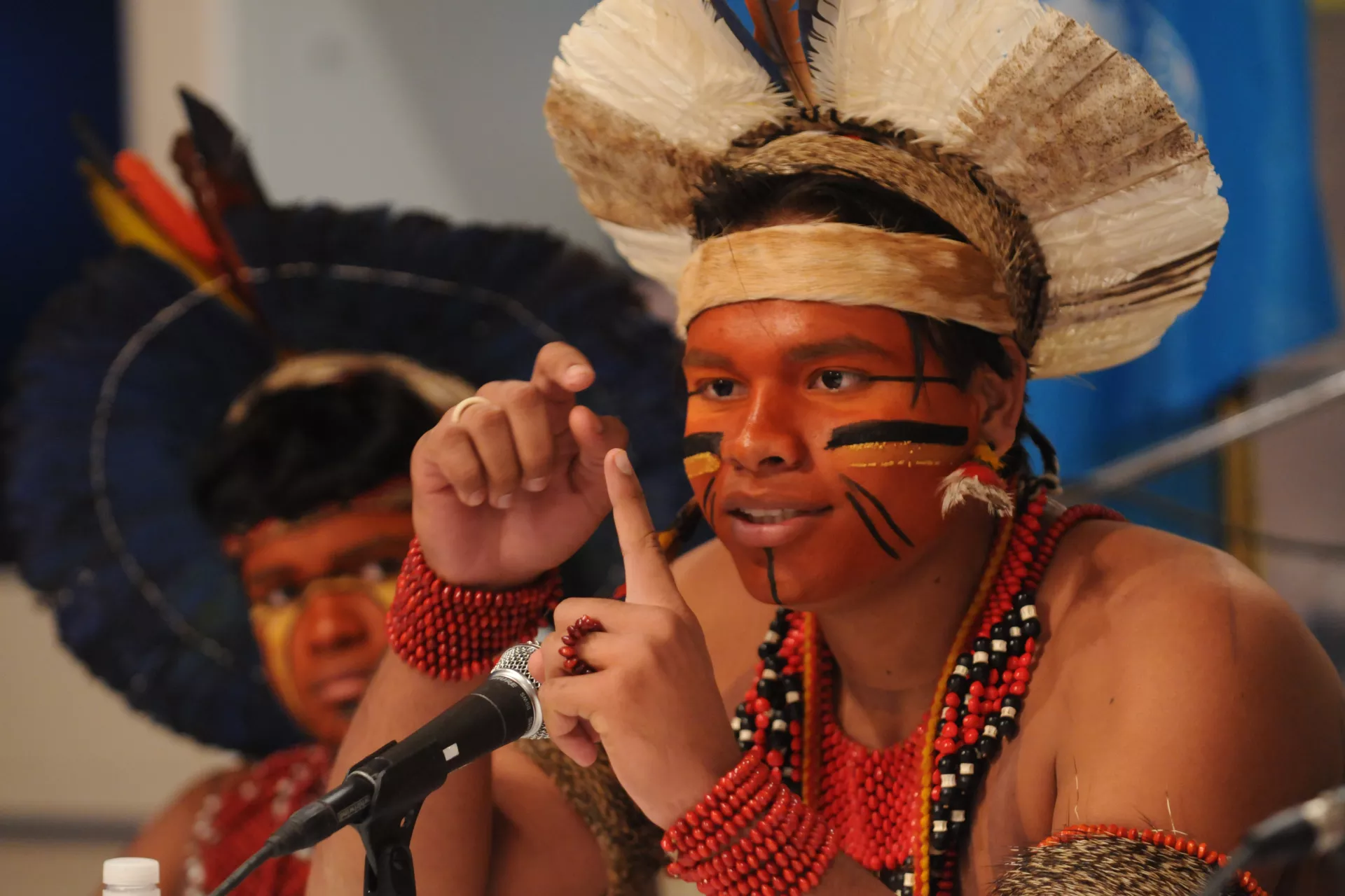 um jovem ind&iacute;gena, com pinturas no rosto e cocar, fala na sede das Na&ccedil;&otilde;es Unidas em Nova Iorque
