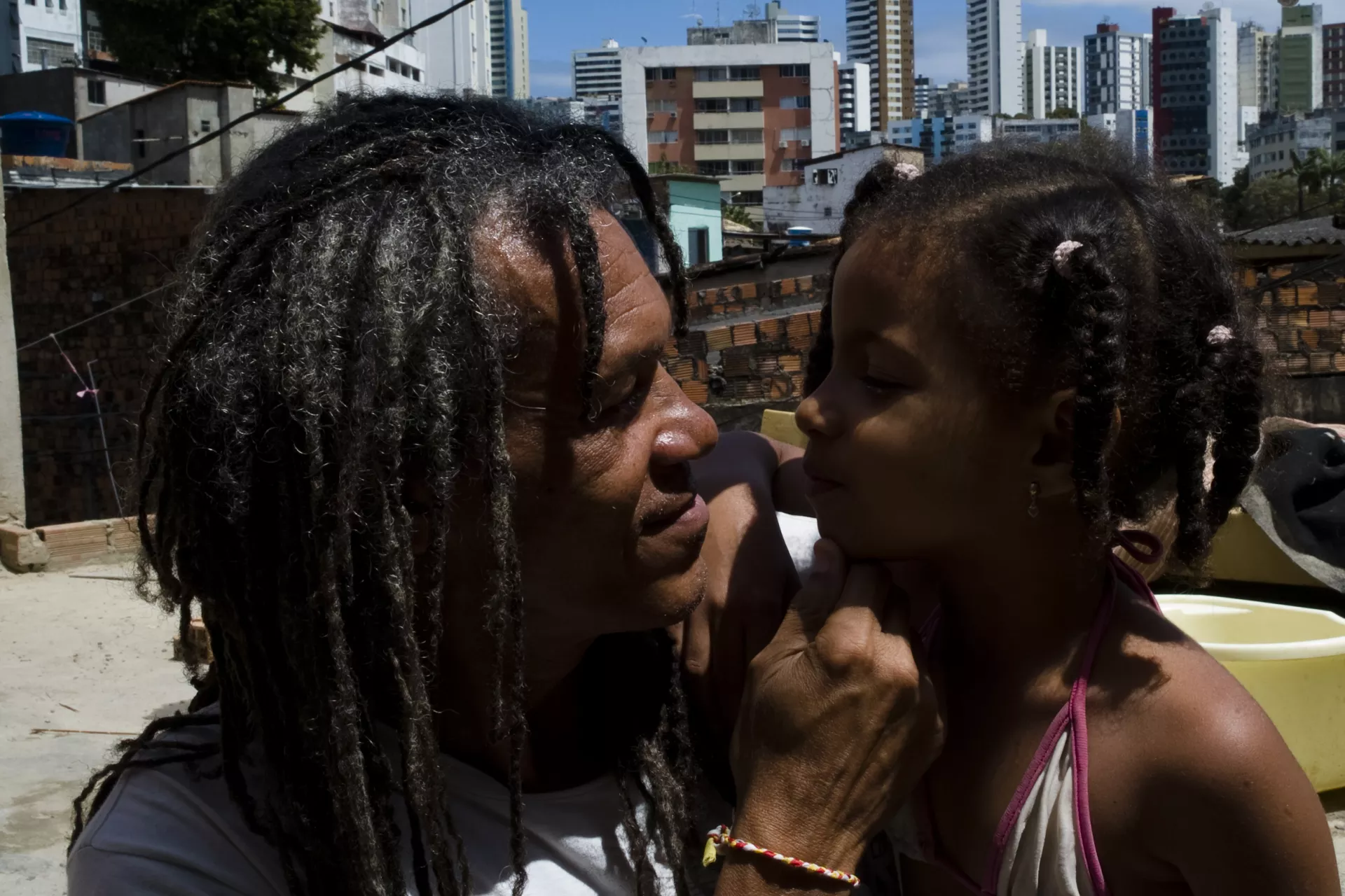 um pai olha nos olhos de sua filha. os dois est&atilde;o sorrindo.