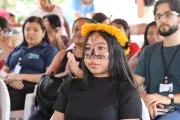 jovem ind&iacute;gena com adere&ccedil;o amarelo na cabe&ccedil;a e pintura tradicional no rosto