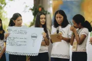grupo de 4 jovens ind&iacute;genas apresenta trabalho segurando cartolina