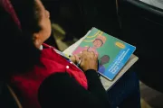 Foto mostra uma pessoa de costas segurando uma publica&ccedil;&atilde;o