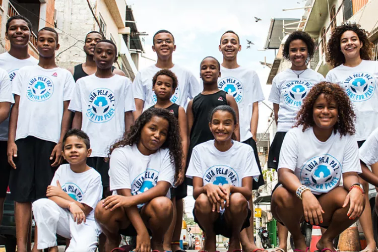 Parte da capa da publica&ccedil;&atilde;o mostra a foto de um grupo de crian&ccedil;as e adolescentes com a camiseta da ONG Luta pela Paz. Eles est&atilde;o formados em duas fileiras. As pessoas na frente est&atilde;o agachadas.