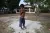 Menino sem camisa, em pé, em frente de uma escola, no Pará