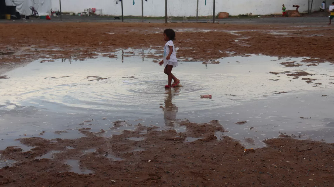 menina pisa em uma po&ccedil;a de &aacute;gua