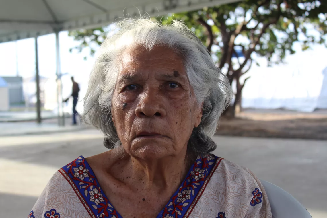Uma mulher venezuelana do abrigo Pricum&atilde; olha seriamente para a foto