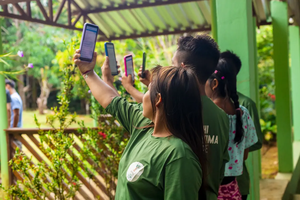 jovens ind&iacute;genas com bra&ccedil;os esticados com celular na m&atilde;o