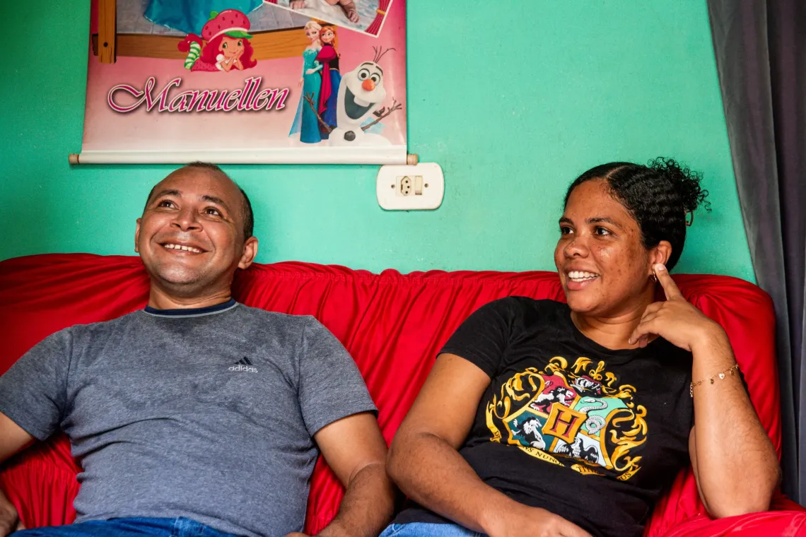 homem e mulher sentados em sof&aacute; vermelho