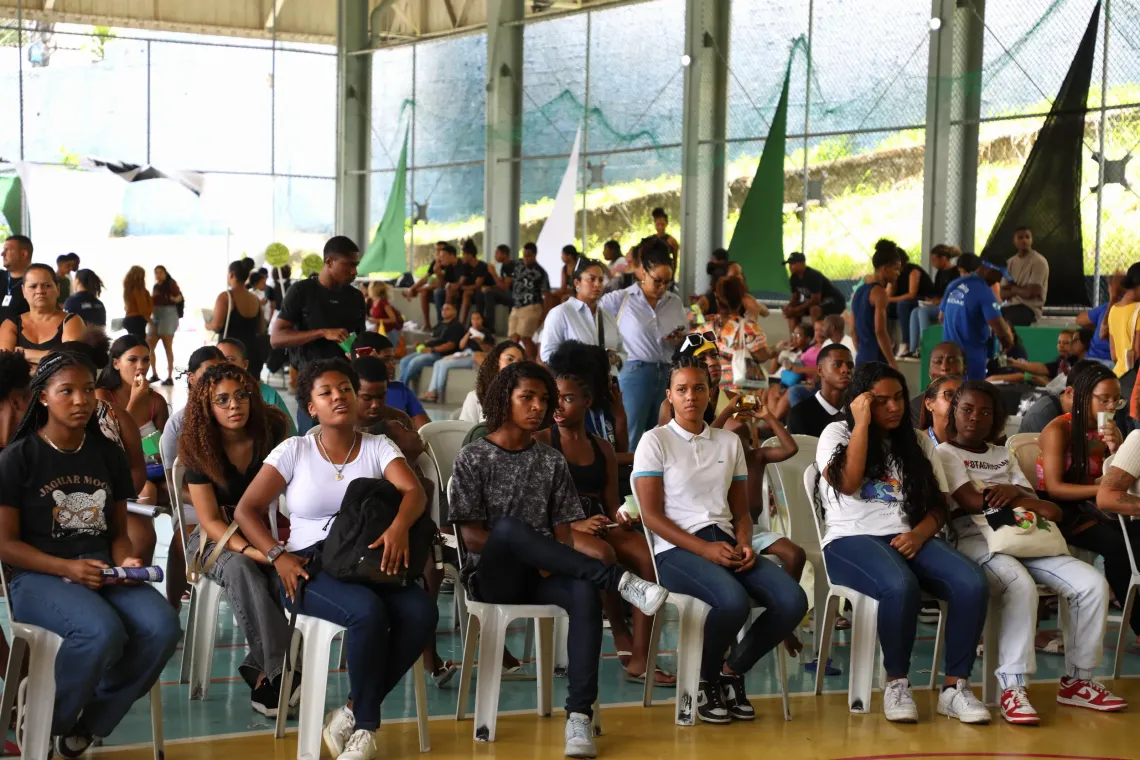 jovens sentados em cadeiras assistem a apresenta&ccedil;&atilde;o