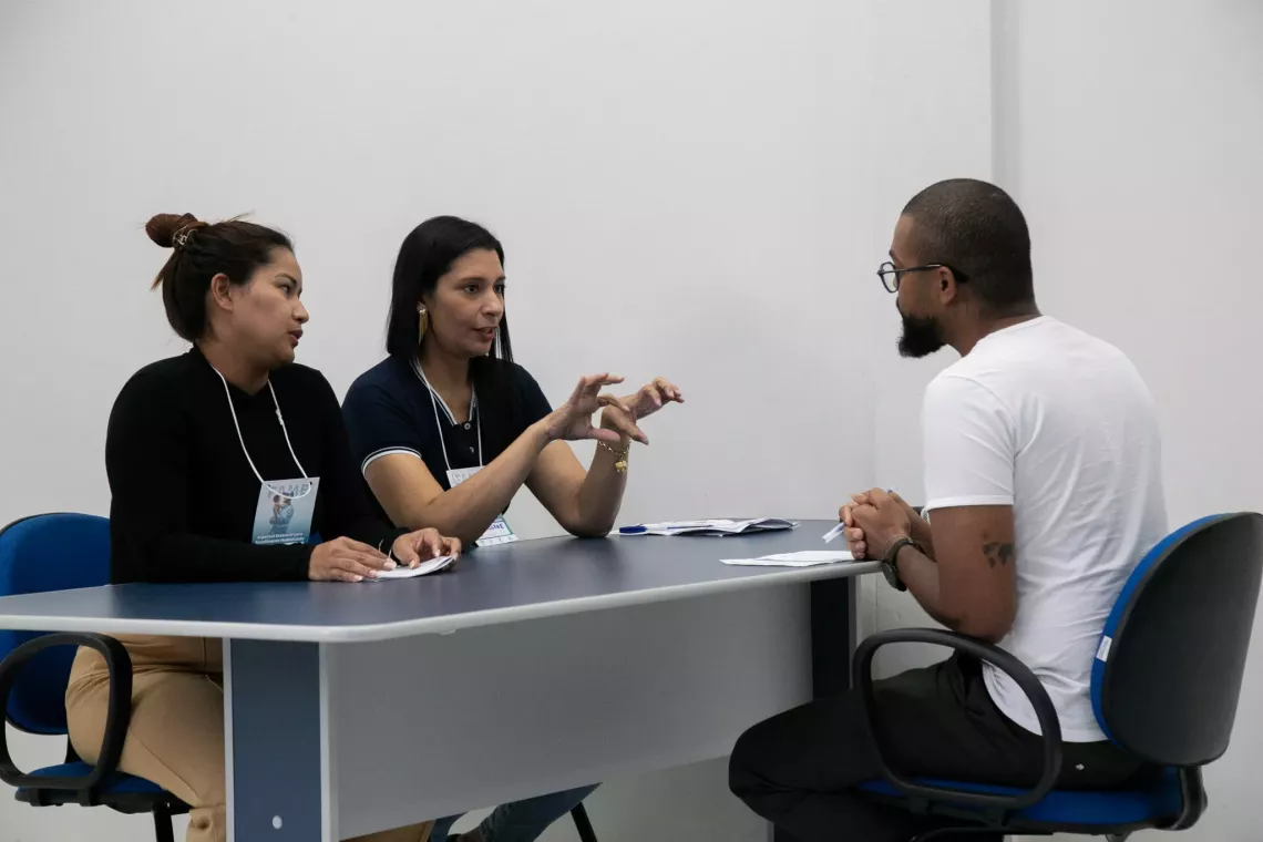 duas mulheres prestam atendimento a um homem