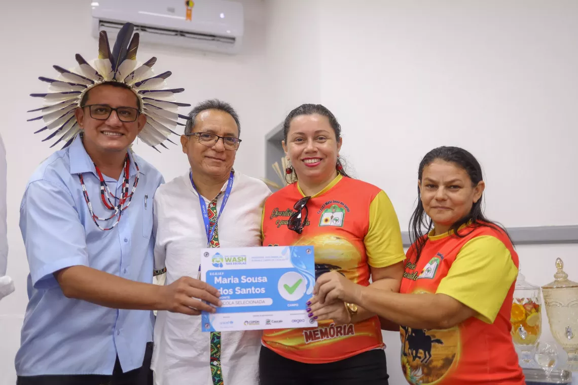 quatro pessoas possam para foto segurando certificado