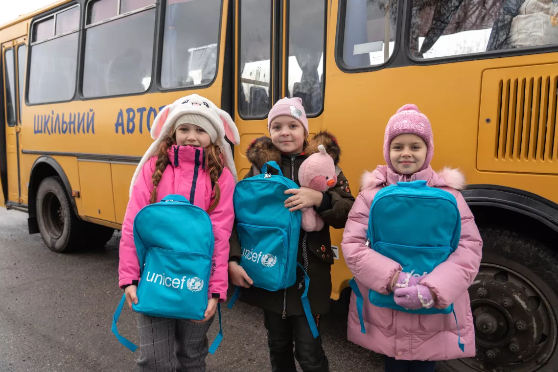 Foto mostra um grupo de crian&ccedil;as com mochilas do UNICEF.
