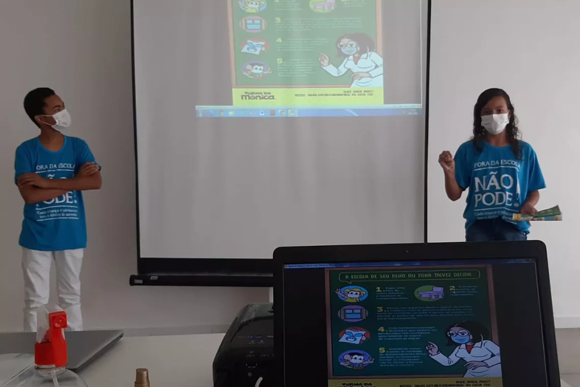 Foto mostra dois adolescentes fazendo uma apresenta&ccedil;&atilde;o de PowerPoint.