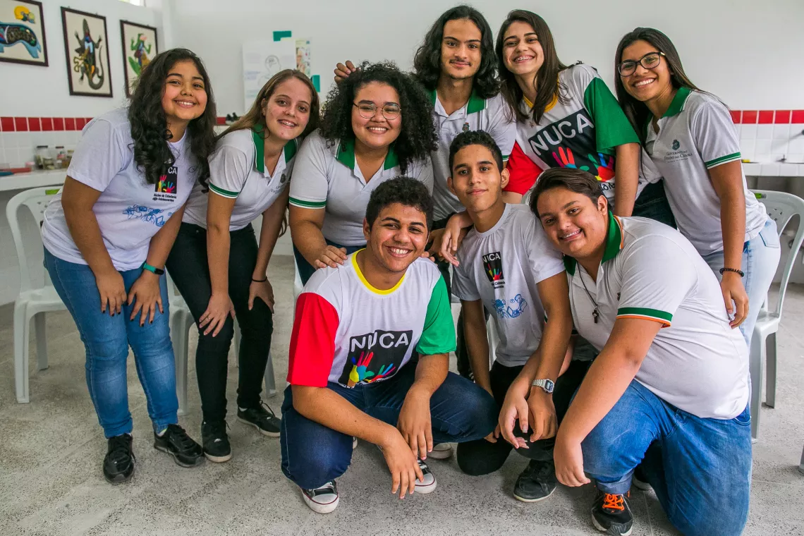 Nove adolescentes, entre eles Felipe, posam para a foto. Eles est&atilde;o dentro da sala de aula. Seis est&atilde;o em p&eacute;. Tr&ecirc;s na frente de joelhos.