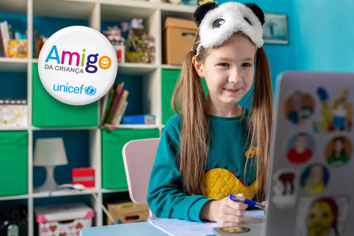 Foto mostra uma menina mexendo em um computador