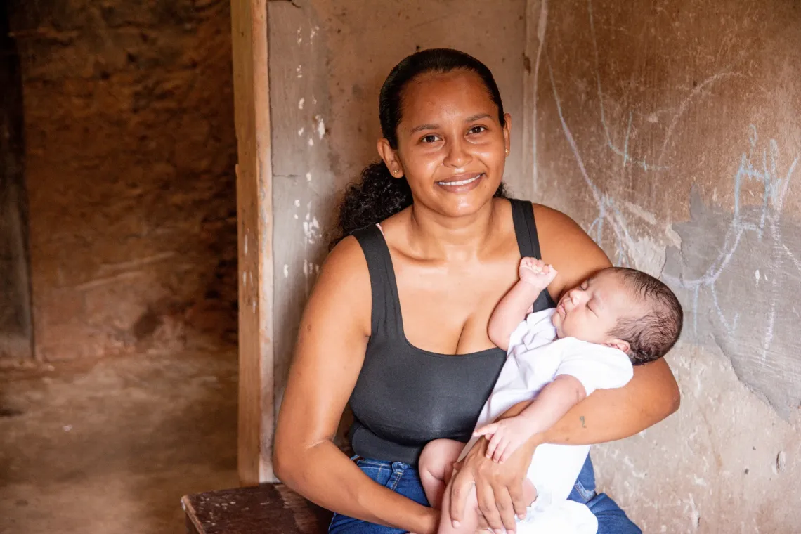 mulher segura beb&ecirc; no colo