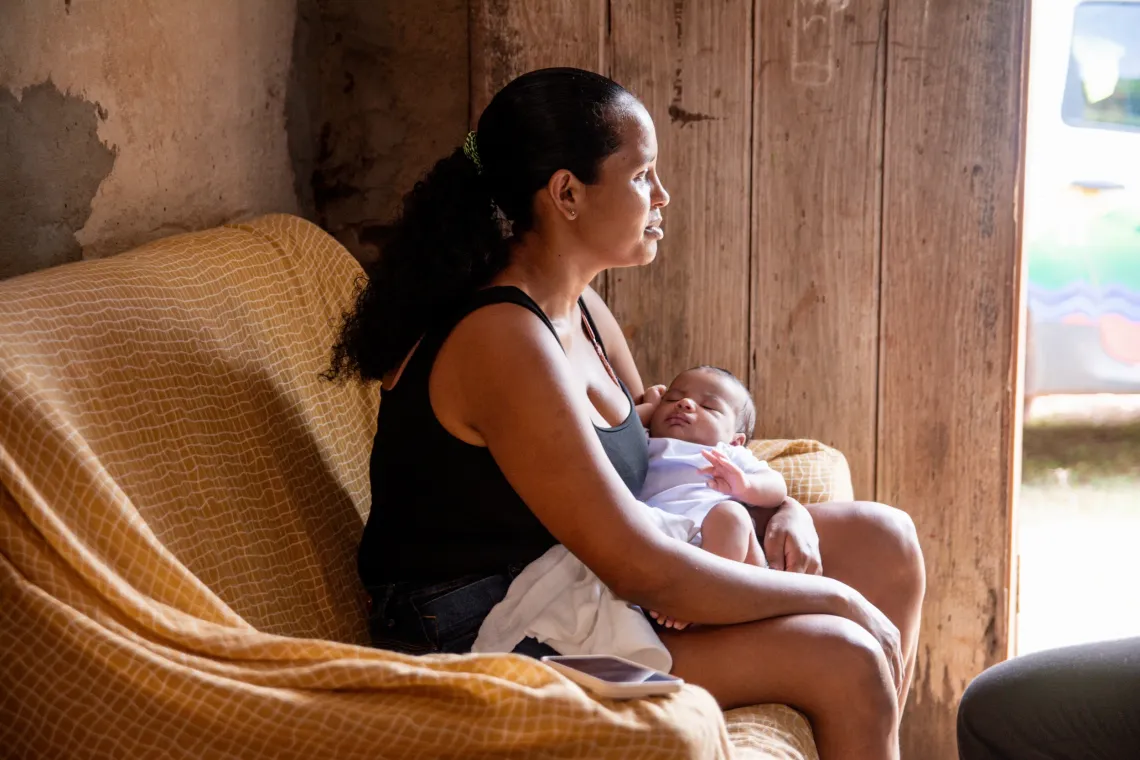 mulher em sof&aacute; com beb&ecirc; no colo