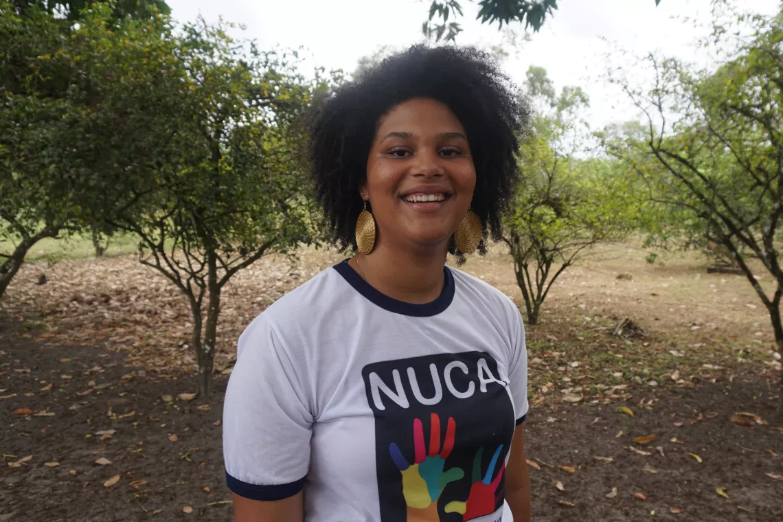 Foto mostra uma jovem sorrindo para a c&acirc;mera