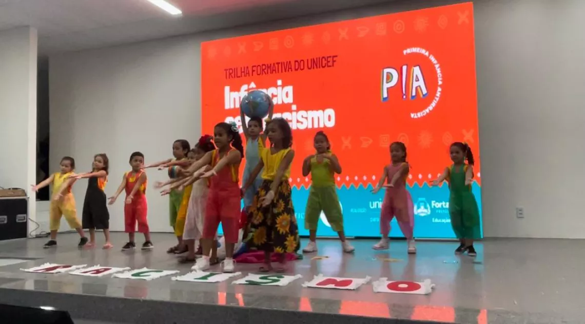 Foto mostra crian&ccedil;as se apresentando em um palco