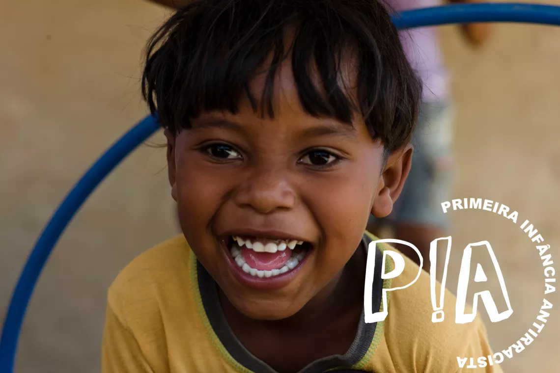 Foto mostra um menino pequeno sorridente