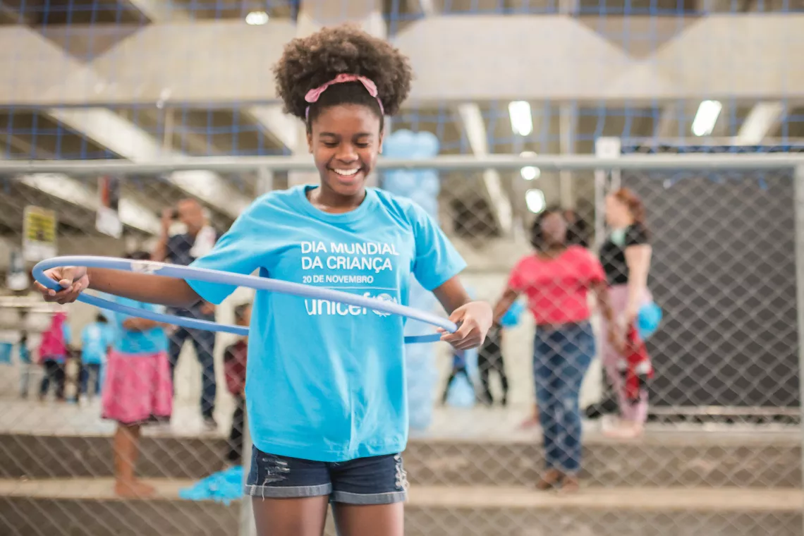Foto mostra uma adolescente brincando com um bambol&ecirc;
