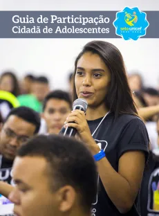 Capa do guia mostra uma adolescente falando para outros adolescentes. Ela segura um microfone.