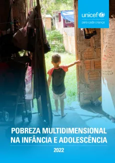 Foto mostra um menino pequeno de costas parado em uma porta aberta