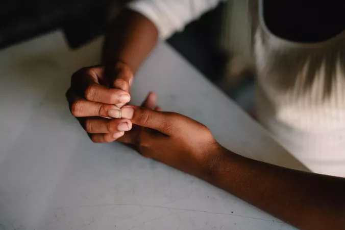M&atilde;os e bra&ccedil;os de crian&ccedil;a sobre uma mesa