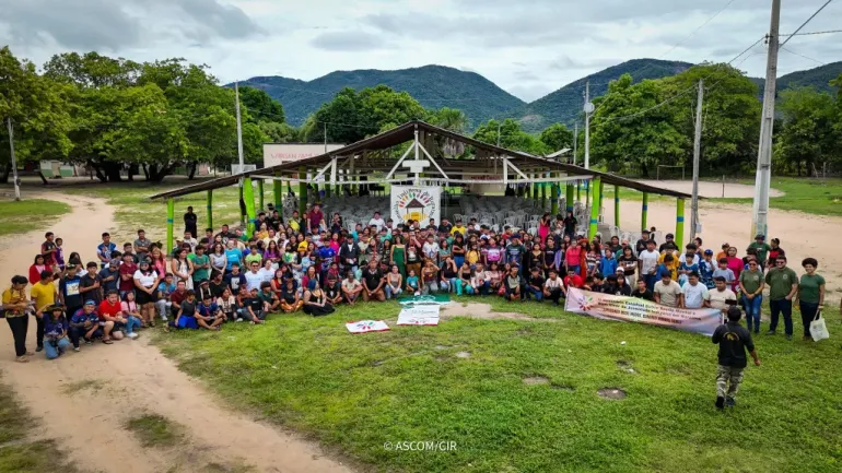 grupo de ind&iacute;genas posa para foto em frente a galp&atilde;o