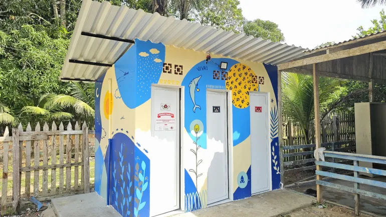 banheiro de paredes pintadas com desenhos azuis e amarelos
