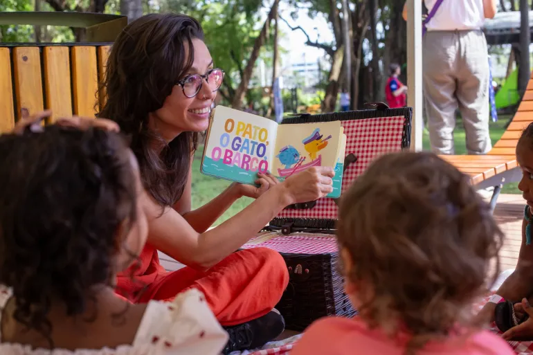 mulher faz atividade de leitura para crian&ccedil;as pequenas durante a semana do beb&ecirc; no Recife, uma iniciativa do UNICEF