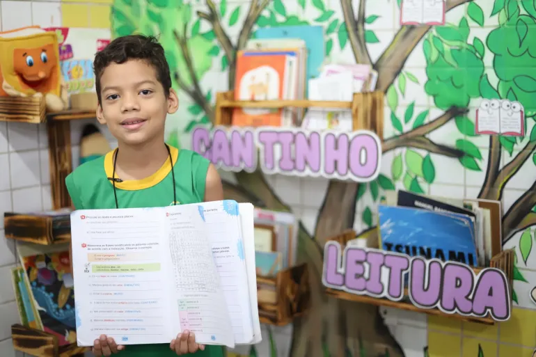 menino segura livro aberto em escola