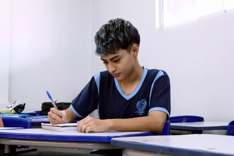 jovem escreve no caderno