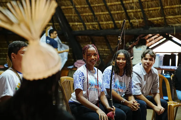 adolescentes reunidos e sentados, um deles com chap&eacute;u t&iacute;pico da tribo xucuru de pesqueira