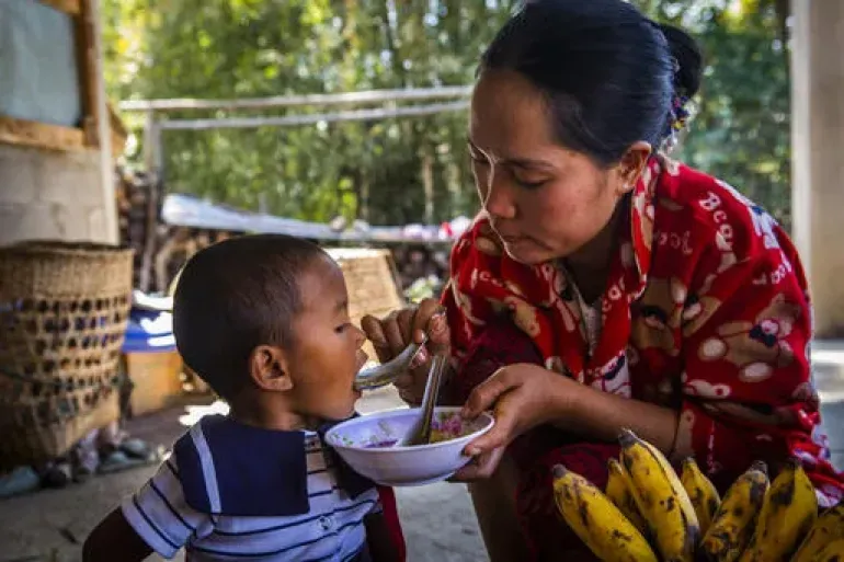 M&atilde;e alimentando sua filha com ingredientes dispon&iacute;veis em seu quintal
