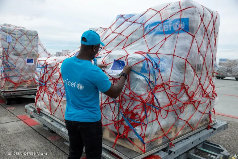 Funcion&aacute;rio do UNICEF vestindo camiseta azul ciano inspeciona suprimentos de emerg&ecirc;ncias enviados &agrave; Venezuela ap&oacute;s terremoto